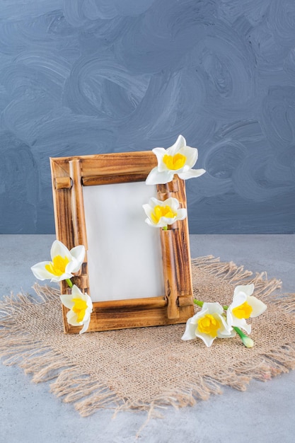 Una cornice in legno con fiori bianchi su un sacco.