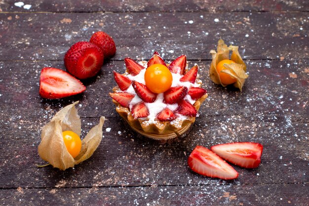 Una deliziosa piccola torta vista dall'alto con crema e frutta fresca a fette sullo zucchero della torta di frutta marrone scrivania