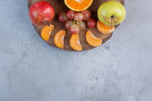 Una deliziosa porzione di frutta su una tavola di legno su sfondo di marmo.