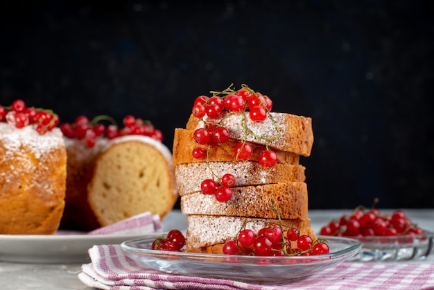 Una deliziosa torta di vista frontale con mirtilli rossi freschi sullo zucchero bianco della bacca del tè del biscotto della torta dello scrittorio