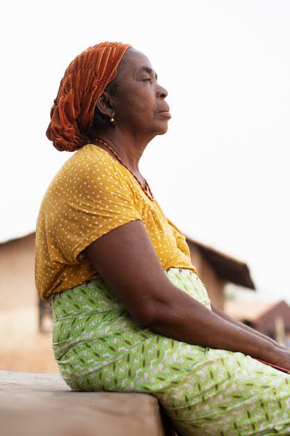 Una donna africana seduta all'aperto.