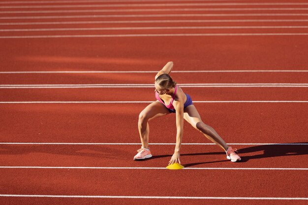 Una donna caucasica atleta femminile che si esercita da sola allo stadio pubblico