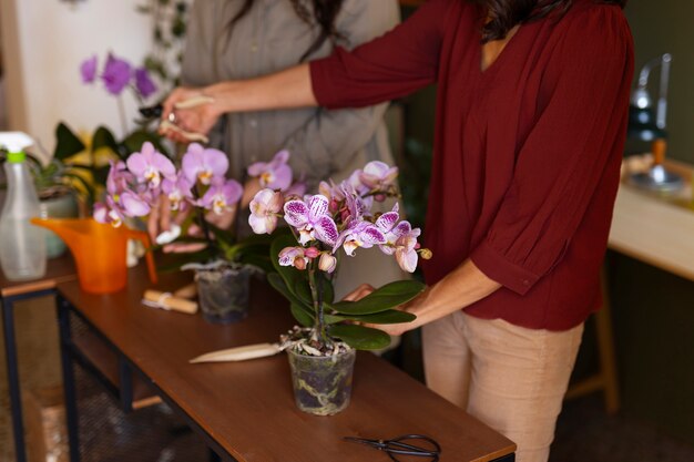 Una donna che decora la sua casa con orchidee