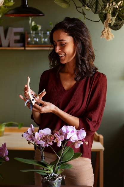 Una donna che decora la sua casa con orchidee