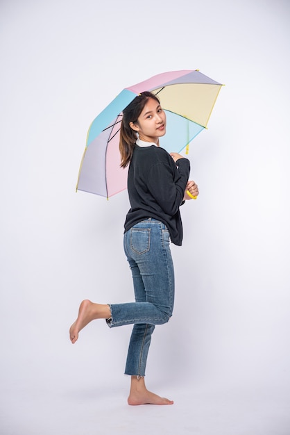 Una donna che indossa una camicia nera e in piedi con un ombrello