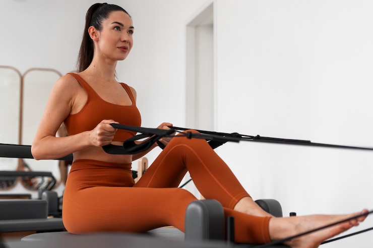 Foto gratuito una donna che prende un corso di pilates per riformare