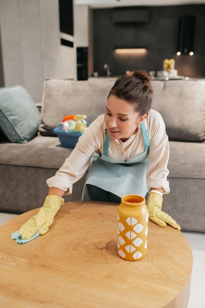 Una donna che pulisce un surfcase da tavolo con un disinfettante