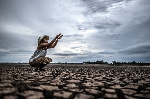 Una donna è seduta a chiedere pioggia nella stagione secca, riscaldamento globale