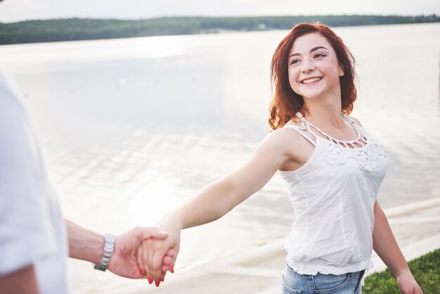 Una donna felice sorridente con un'espressione giocosa e una mano con suo marito.