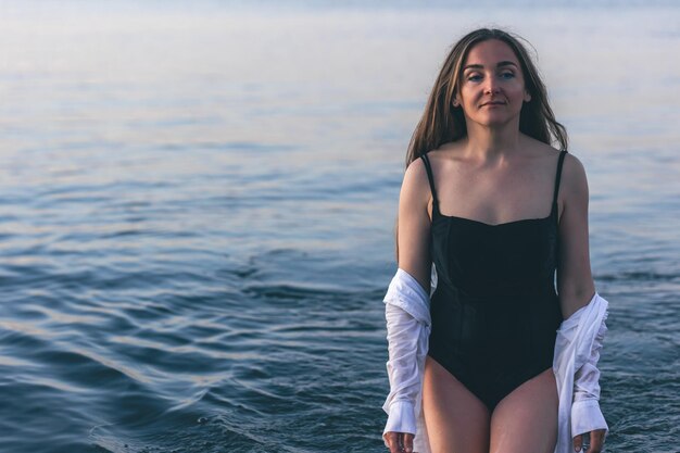 Una donna in costume da bagno e una camicia bianca in mare