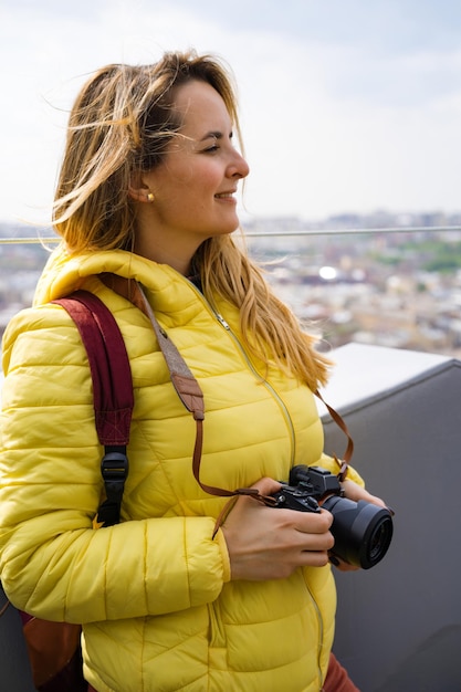una donna in viaggio scatta foto della città dall'alto. Femmina con una macchina fotografica. Fotografa donne