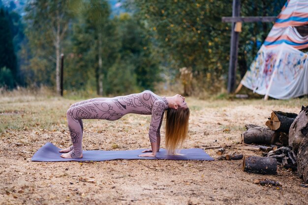 Una donna pratica yoga al mattino in un parco all'aria aperta.