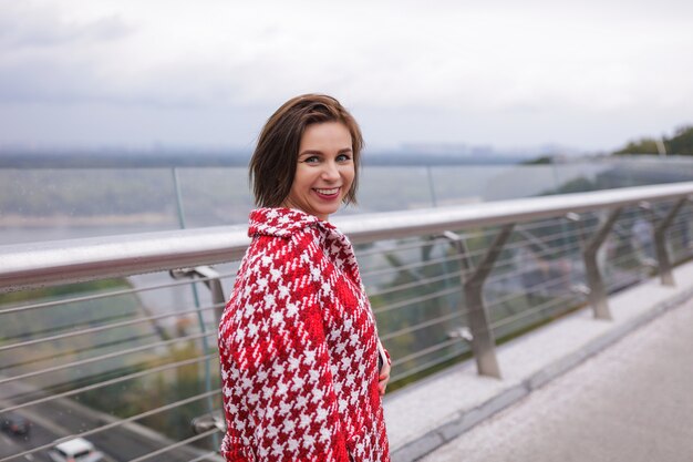 Una donna sorridente di mezza età che indossa abiti autunnali.