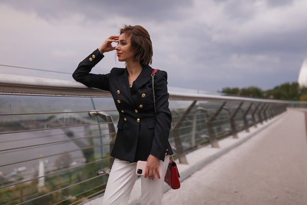 Una donna sorridente di mezza età che indossa abiti autunnali.