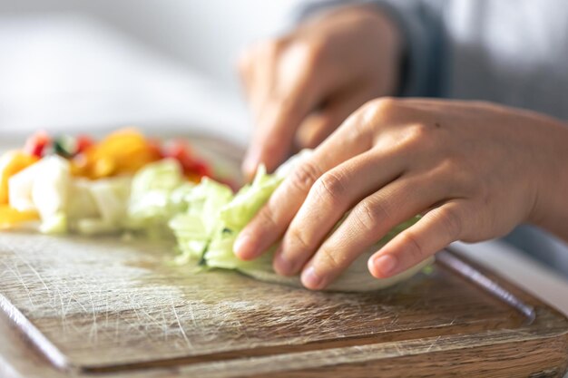 Una donna taglia le verdure su un tagliere