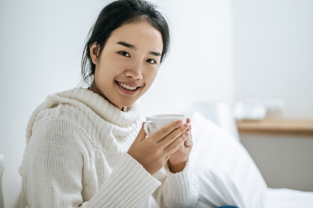 Una donna tiene una tazza di caffè.