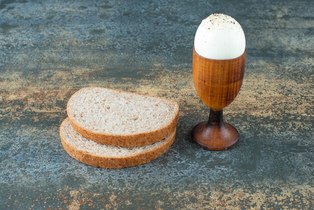 Una fetta di pane con bollito su fondo di marmo