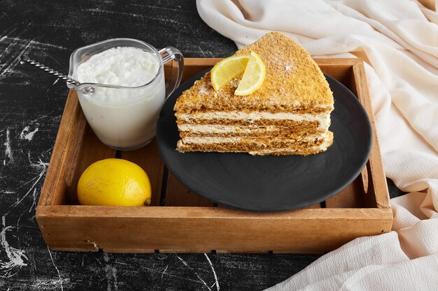 Una fetta di torta al limone con una tazza di ricotta.