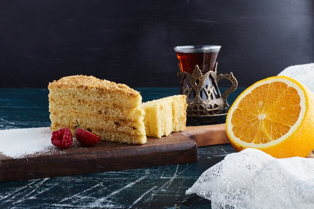 Una fetta di torta al miele con un bicchiere di tè.