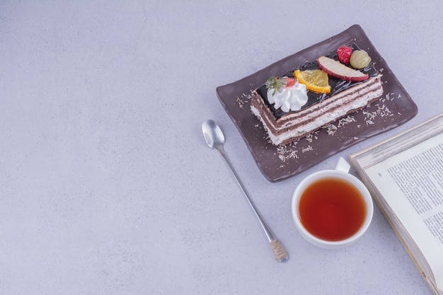 Una fetta di torta di crepe al cioccolato con una tazza di tè e frutta