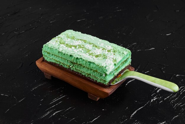 Una fetta di torta verde su una tavola di legno.