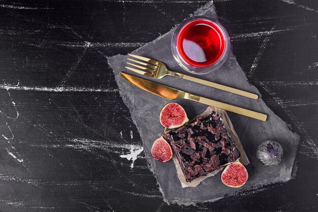 Una fetta quadrata di cheesecake al cioccolato con bevanda rossa