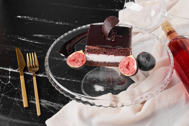 Una fetta quadrata di cheesecake al cioccolato su una tavola di vetro.