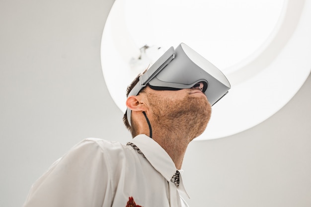Una foto ad angolo basso di un medico maschio futuristico che indossa occhiali VR in un ospedale