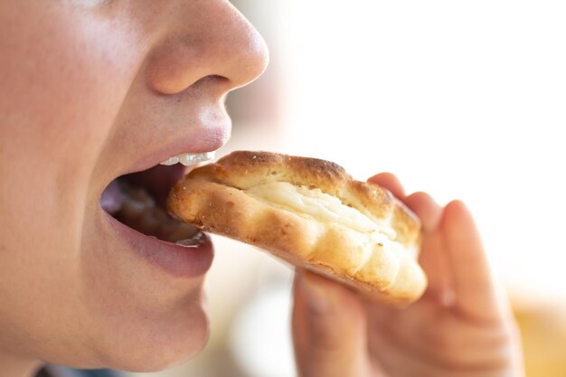 Una foto dettagliata di una donna che mangia un panino fresco