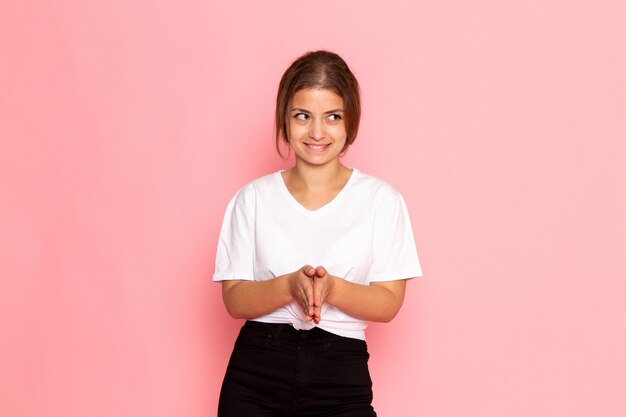 Una giovane bella femmina di vista frontale in camicia bianca che posa con l'espressione contentissima