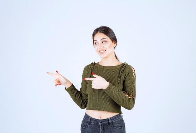 Una giovane donna adorabile modello in verde che punta al suo fianco