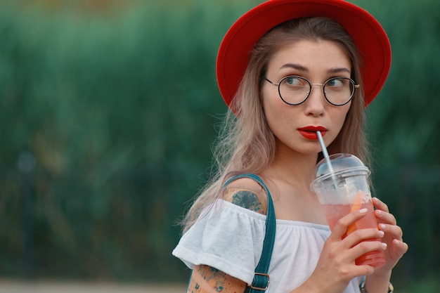 Una giovane donna alla moda con un drink rinfrescante