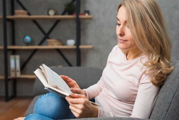 Una giovane donna attraente che legge il libro