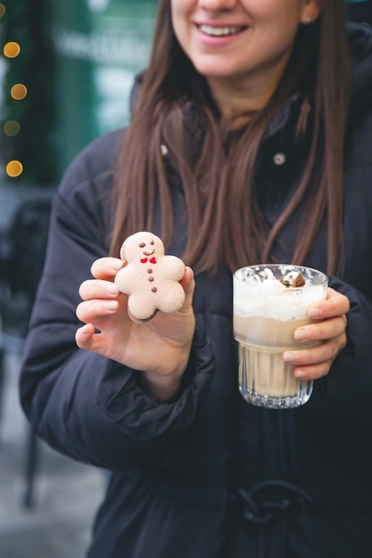 Una giovane donna beve caffè con un ragazzo di pan di zenzero in un caffè in strada