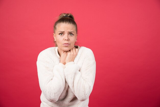 Una giovane donna che tiene la gola e soffre di dolore