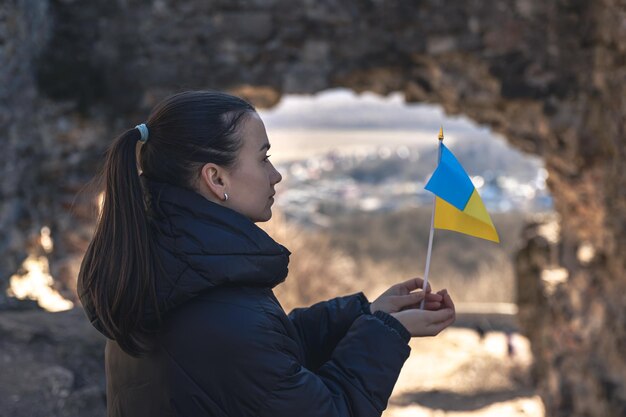 Una giovane donna con la bandiera dell'ucraina in mano