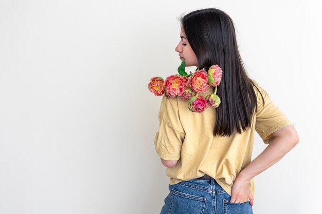 Una giovane donna con un mazzo di fiori su sfondo bianco