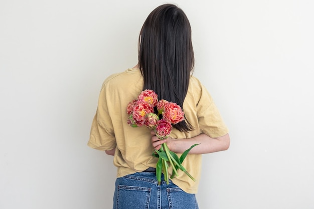 Una giovane donna con un mazzo di fiori su sfondo bianco