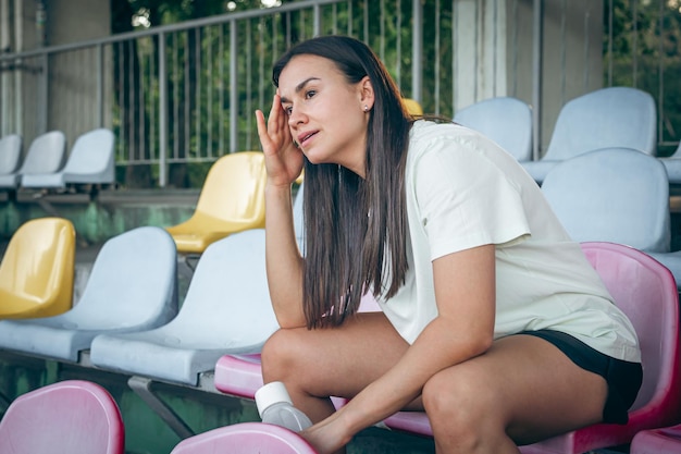 Una giovane donna con una bottiglia d'acqua dopo l'allenamento allo stadio