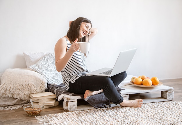 Una giovane donna lavora in remoto al computer di casa. Libero professionista e lavoro su Internet.