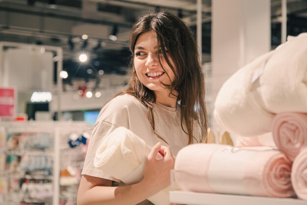 Una giovane donna sceglie le coperte per l'interno di una casa in un negozio di bricolage