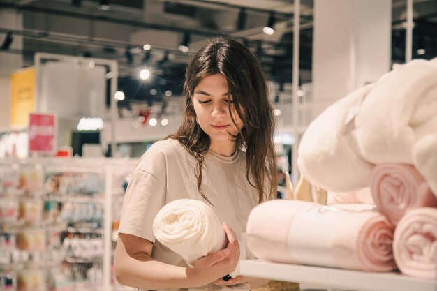 Una giovane donna sceglie le coperte per l'interno di una casa in un negozio di bricolage