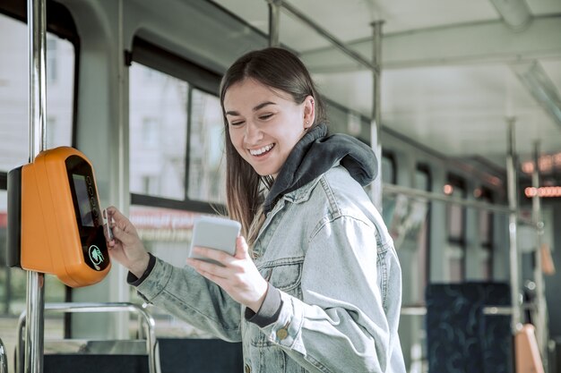 Una giovane donna senza contatto paga i trasporti pubblici