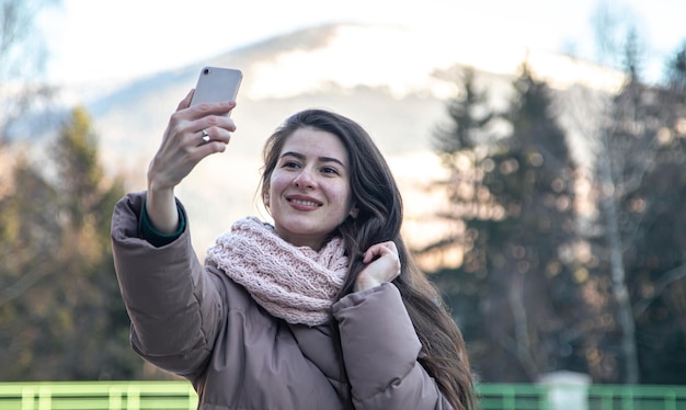 Una giovane donna si fa un selfie durante una passeggiata in montagna