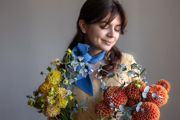 Una giovane donna tiene in mano un mazzo di fiori di crisantemo