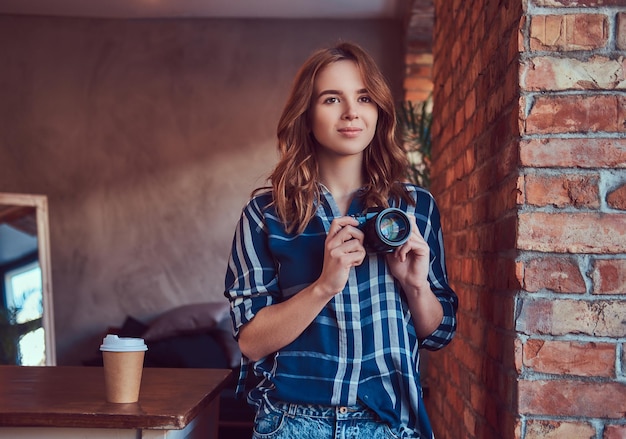 Una giovane e affascinante fotografa si trova in una stanza con un soppalco