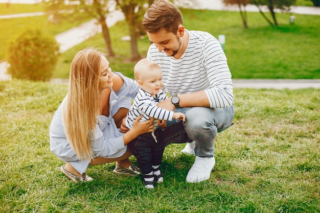 Una giovane e bella madre bionda in un vestito blu, insieme al suo bell&#39;uomo