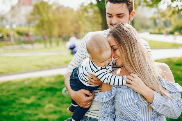 Una giovane e bella madre bionda in un vestito blu, insieme al suo bell&#39;uomo