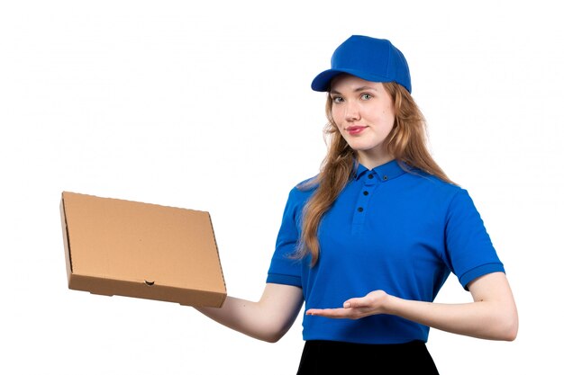 Una giovane lavoratrice femminile del corriere femminile di vista frontale del pacchetto di consegna dell'alimento della tenuta di servizio di consegna dell'alimento che sorride sul bianco