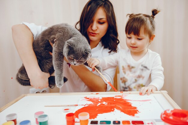 Una giovane madre, insieme alla sua piccola figlia dipinge su carta